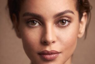 Modern studio headshot of a confident young adult woman (21+) on a clean backdrop