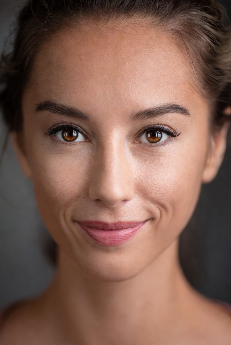 Studio headshot prompt of an adult woman with Rembrandt lighting and clean background