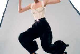 Stunning young woman mid-jump in a white cyclorama studio with high-key lighting, wearing a modern high-fashion outfit, photoreal 8K