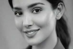 Clean softbox-lit studio headshot of a beautiful young adult woman on a light gray backdrop