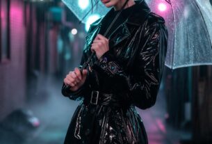 Stunning young woman standing in Tokyo rain under neon signs wearing a glossy vinyl trench coat and combat boots, photoreal 8K nightlife look